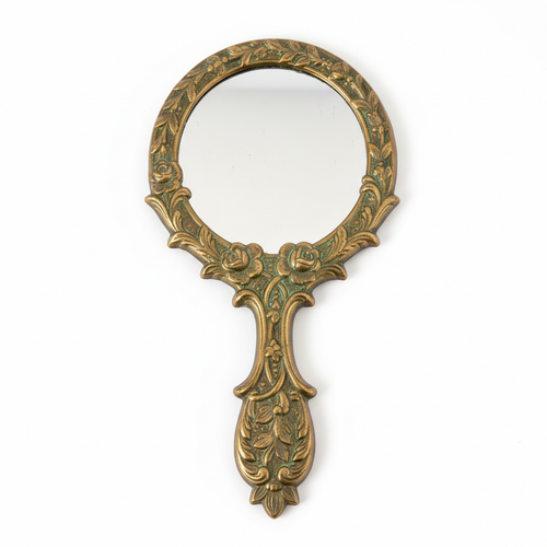 Victorian brass hand mirror with ornate floral engravings and aged patina